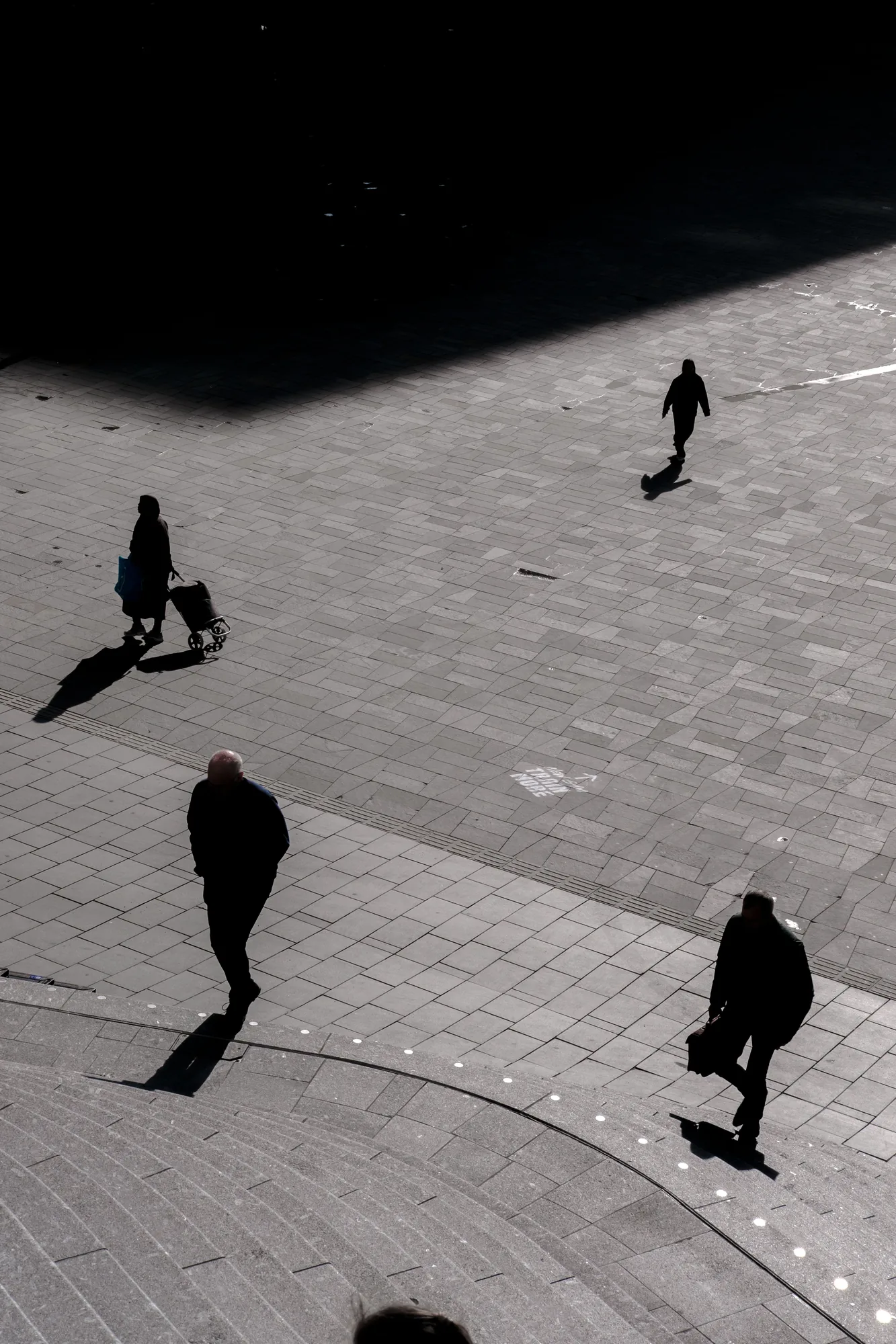 Three figures and their long shadows