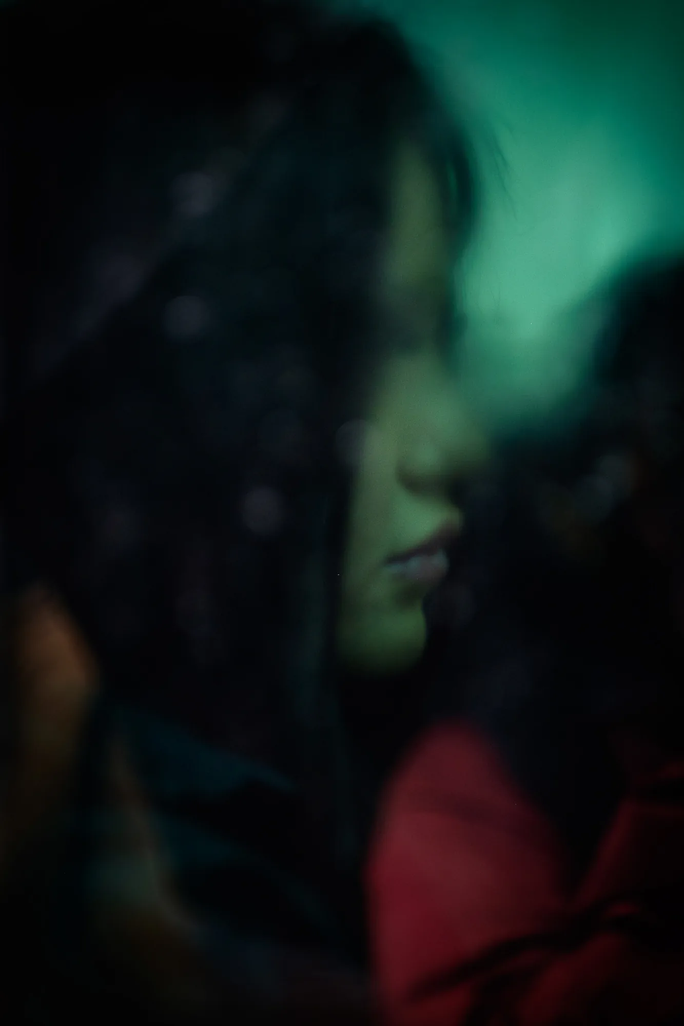 Woman in profile, through rain-spattered glass